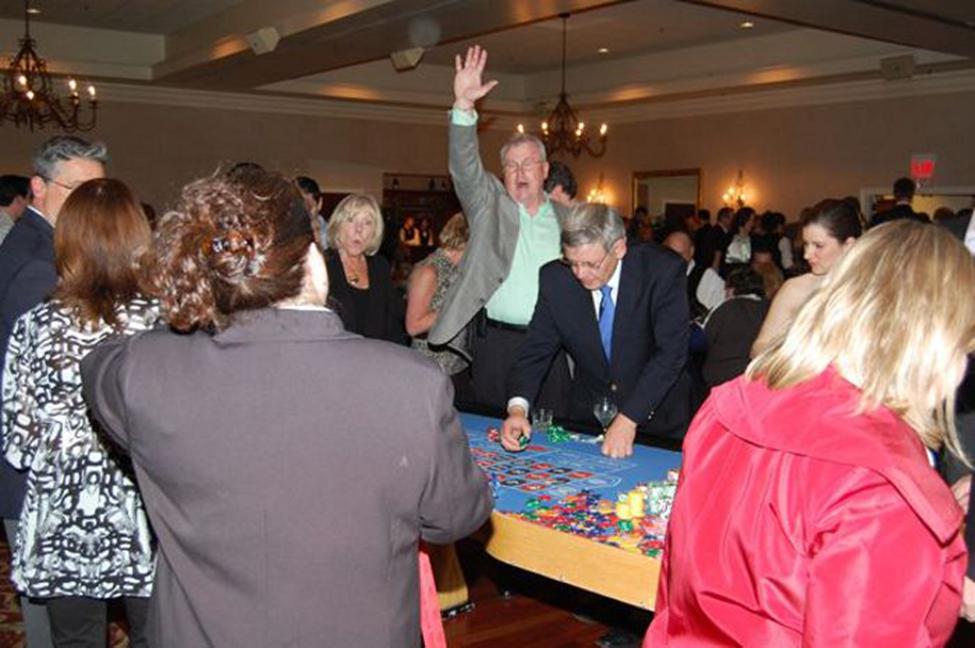 Guests playing at a professional casino table during an office casino night event